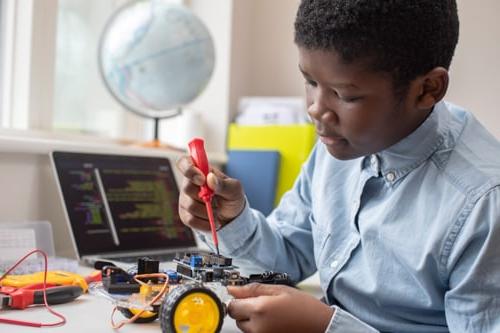 Connections Academy student works on a STEM project building a small robot which will respond to code.